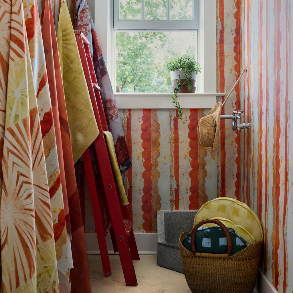 Modernity (Rubber Duck) and Modernity (Preppy) round pillows in a basket beside Cassis wallpaper