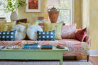 Modernity (Preppy) lumbar, Modernity (Sachet) round and Palmetto pillows on a sofa in a Palm wallpaper living room