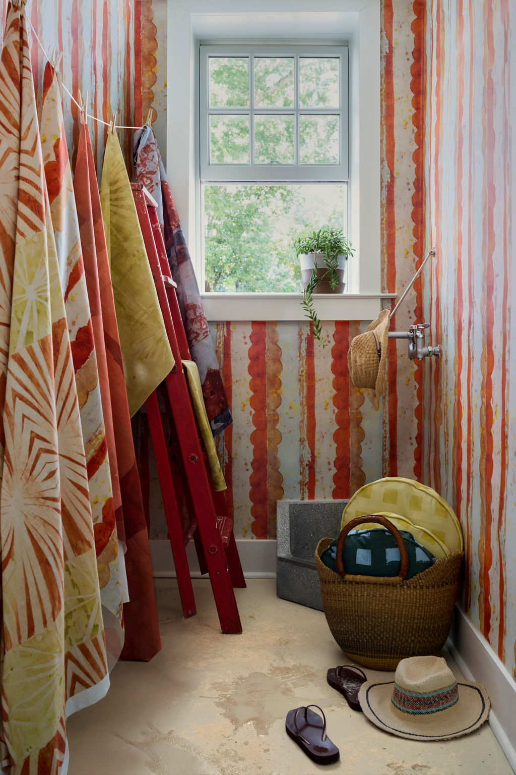 Modernity (Rubber Duck) and Modernity (Preppy) round pillows in a basket beside Cassis wallpaper