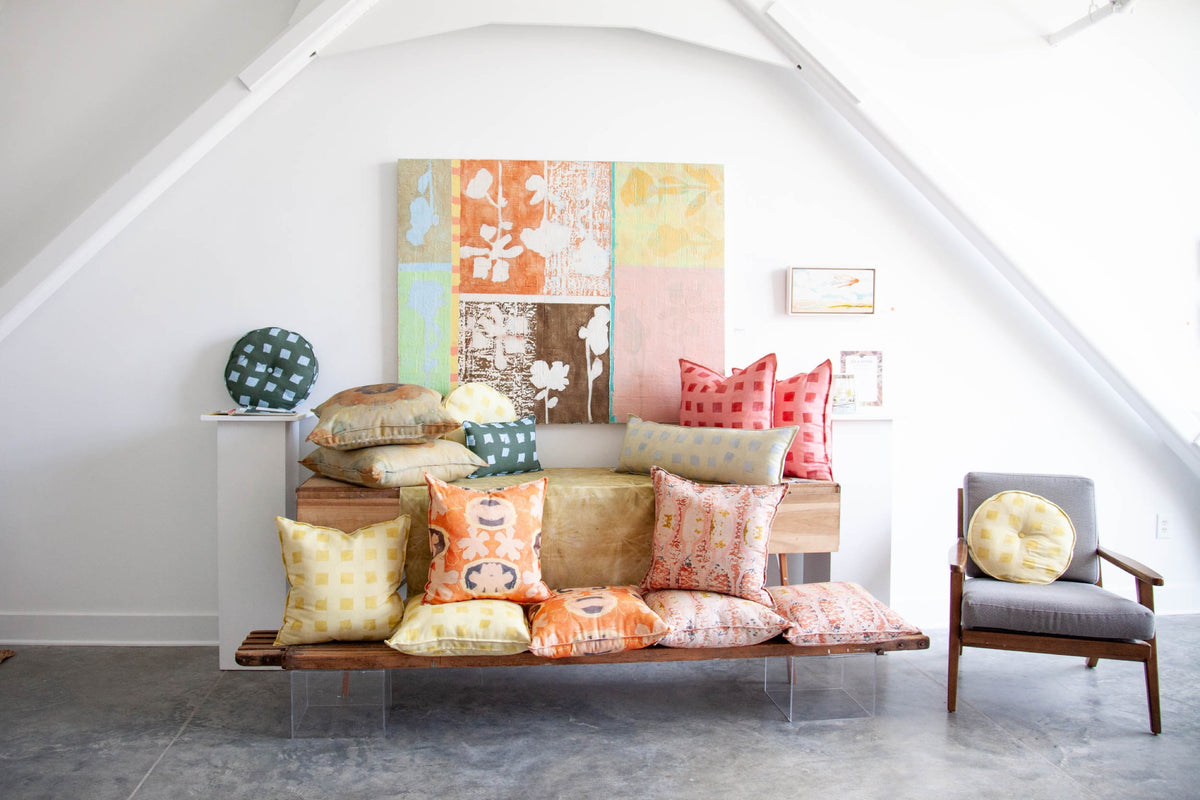 Teresa Roche Textiles pillows styled on a bench in the Greenville studio